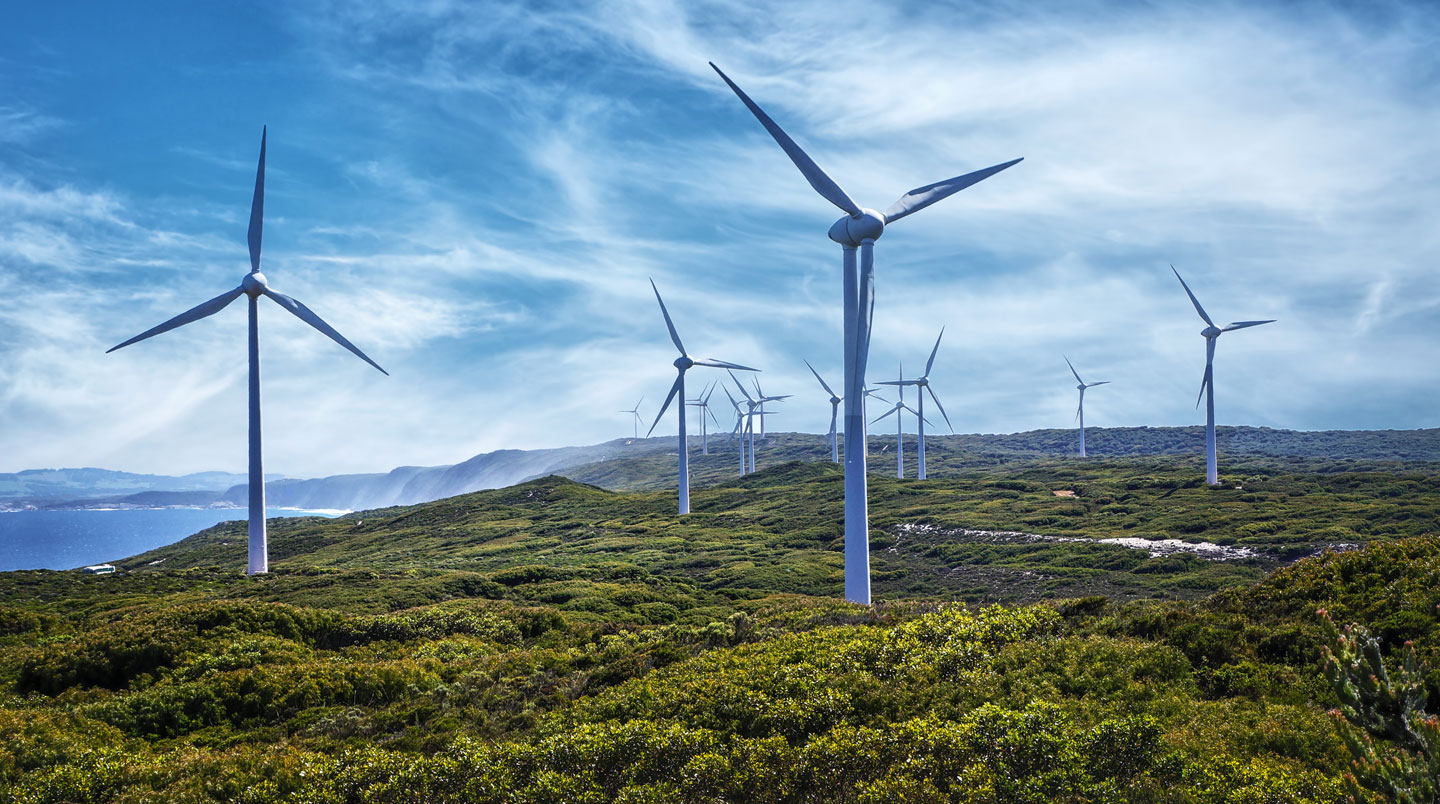 Parco eolico con turbine sotto un cielo minaccioso con temporale in avvicinamento